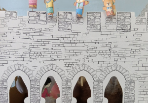 Dzieci schowane za makietą zamku animują cztery kukiełki przedstawijace misie.